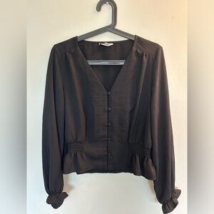 Black blouse, professional fit with fabric buttons. Cinches at the waist.